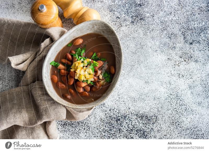 Bohnengemüsesuppe in der Schale serviert Hintergrund Beton Koriander Küche Schüssel Speise essen Essen erstes Gericht Lebensmittel Knoblauch Feinschmecker Kraut