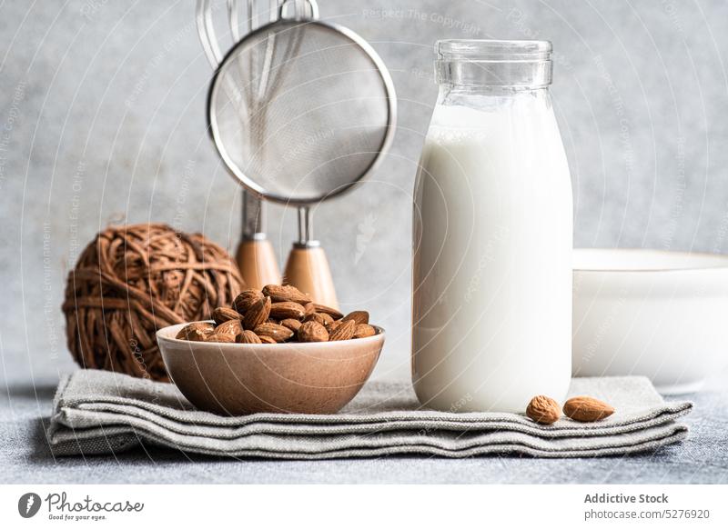 Rohe Mandeln und natürliche Milch und in der Flasche melken Veganer Glas Schalen & Schüsseln roh Beton Koch milchfrei trinken flache Verlegung Lebensmittel