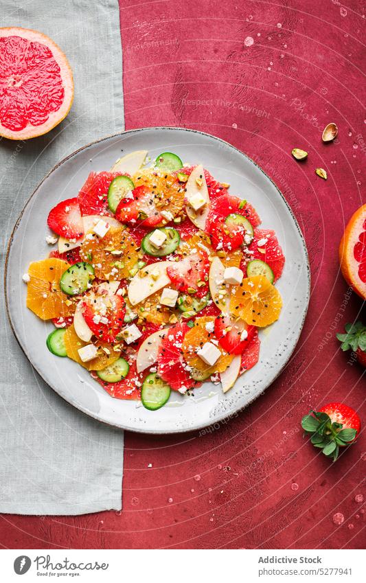 Leckerer Salat mit frischen Früchten Salatbeilage Apfel Käse orange Erdbeeren Salatgurke Pistazien Teller Gesundheit Frucht gesunde Ernährung lecker