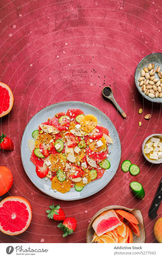 Leckerer Salat mit frischen Früchten Salatbeilage Apfel Käse orange Erdbeeren Salatgurke Pistazien Teller Gesundheit Frucht gesunde Ernährung lecker