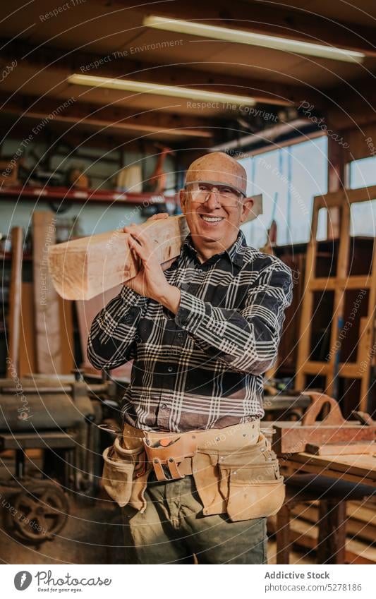 Handwerker bei der Arbeit mit Holz in der Werkstatt Mann Zimmerer Tischlerarbeit Abrichthobelmaschine Lächeln professionell Holzarbeiten behüten hölzern