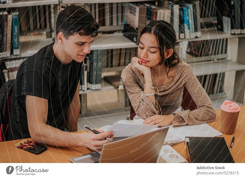 Konzentrierte Schüler arbeiten an einem Projekt in der Bibliothek Zusammensein Laptop lernen Hausaufgabe Apparatur Bildung Fokus Konzentration Hochschule Wissen