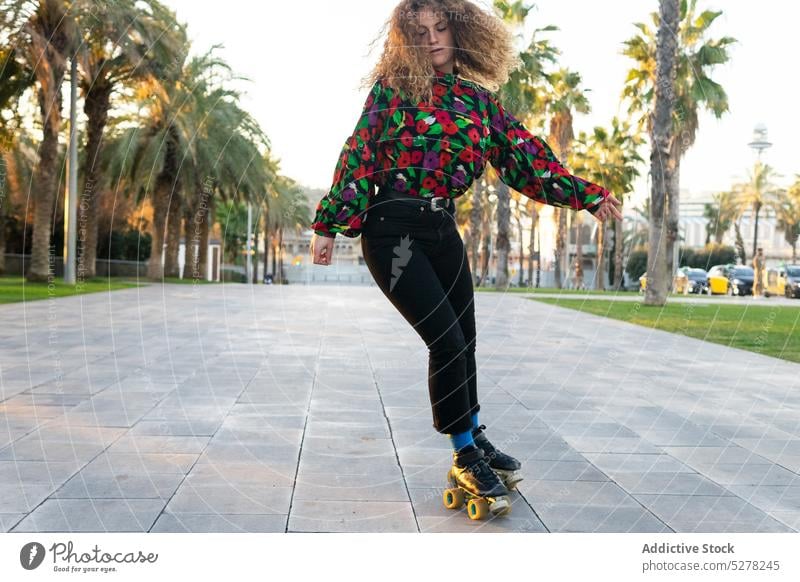 Sportliche Frau fährt auf Rollschuhen im Park Mitfahrgelegenheit Rollerskate Laufsteg Sommer Handfläche Gasse Freizeit tropisch Konzentration jung Zeitvertreib