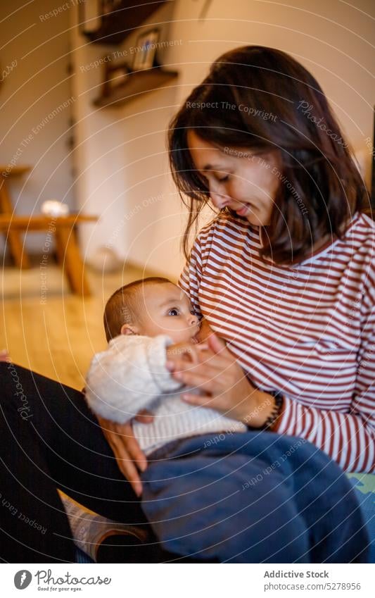 Mutter, die ihr Baby auf dem Boden stillt Windstille stillen Mutterschaft Kind niedlich Eltern Kinderbetreuung Zusammensein Pflege Liebe bezaubernd Wohnzimmer