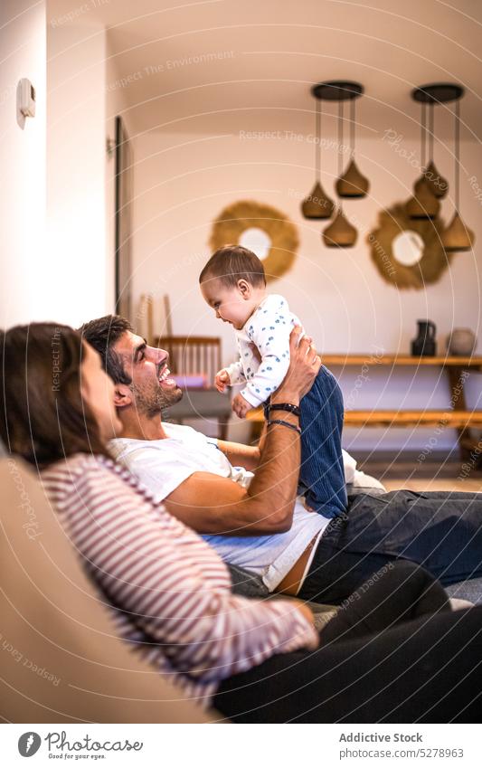 Glückliche Familie, die gemeinsam Zeit auf der Couch verbringt spielen heimwärts Mutter Zusammensein Eltern Kleinkind Liebe Kind Sohn Wochenende Umarmen Vater