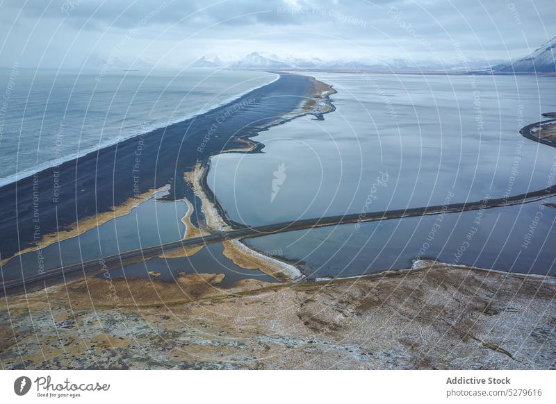 Leere Straße umgeben von Meerwasser in der Nähe von Bergen Fahrbahn MEER Berge u. Gebirge Natur wolkig leer Weg Asphalt Route Wasser Island Europa tagsüber