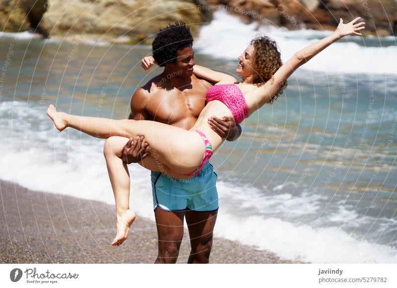 Unterschiedliches Paar, das sich im Sommer am Strand amüsiert Mann Partnerschaft MEER genießen Liebe romantisch Lächeln Freund Freundin vielfältig