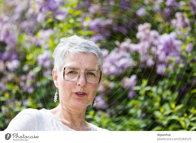 MainFux | Frau mit Flieder Porträt feminin Mensch Haare & Frisuren Erwachsene Außenaufnahme kurzhaarig Gesicht Farbfoto Fliederbusch natürlich Brille