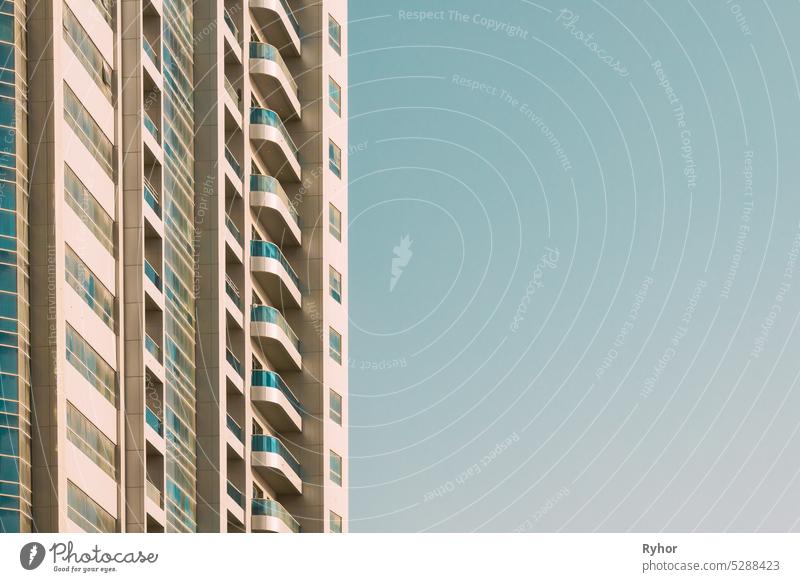 Wall With A Balcony of New Empty Modern Multi-storey Residential Building House In Residential Area On Blue Sky. Nahaufnahme Architektur Großstadt Gebäude