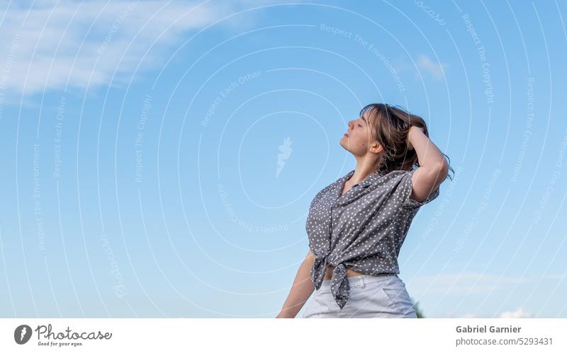 Une magnifique jeune femme regarde vers le ciel, pensive, les mains dans les cheveux schön Mädchen allein Mädchenkörper Menschen Person personne Profil