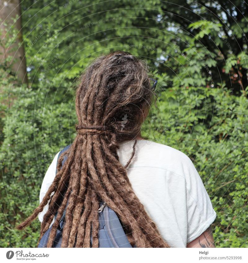 Mainfux-UT | Rückansicht einer Frau mit Dreadlocks Mensch Frisur Haare langhaarig brünett Park Baum Strauch Blätter Rucksack Haare & Frisuren feminin Farbfoto