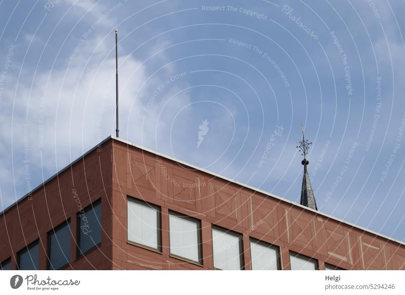 Mainfux-UT | Gebäude mit Flachdach, Fenstern und Antenne, im Hintergrund ein Kirchturm vor blauem Himmel mit Wölkchen Haus Bürogebäude Teilansicht Detailansicht