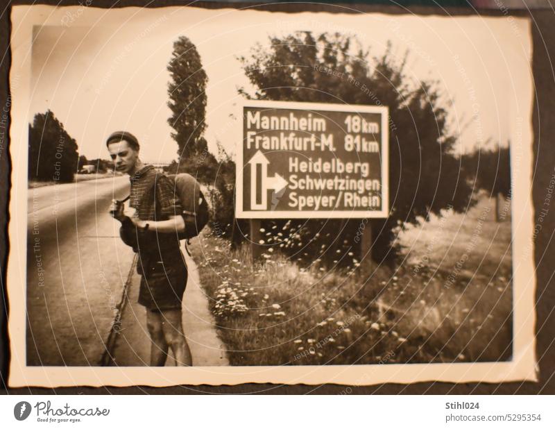 per Anhalter in den 1950ern reisen Autobahn Straße Frankfurt Schwarzweißfoto Mann Rucksack Grünstreifen Heidelberg Schwetzingen Speyer MAnnheim Shorts Hose