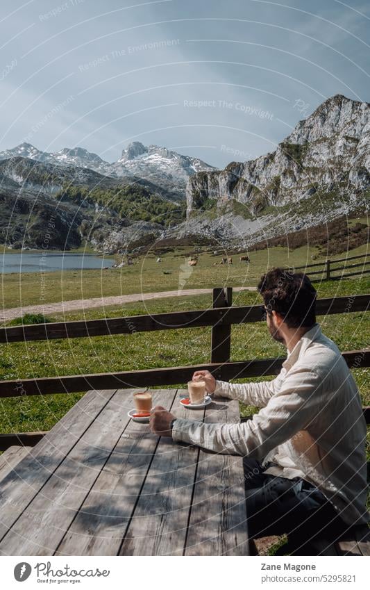 Mann trinkt Kaffee und blickt auf die Bergkette Picos de Europa, Asturien, Spanien Die Picos de Europa Bulnes Urriellu Gipfel Berge u. Gebirge neblig wandern