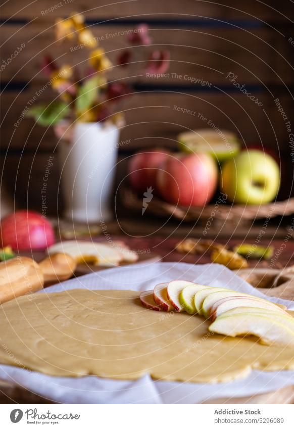 Ungebackener Galette-Apfelkuchen auf Backpapier Pasteten roh Teigwaren ungebacken selbstgemacht vorbereiten Scheibe ungekocht Gebäck Mürbeteig Küche zu Hause