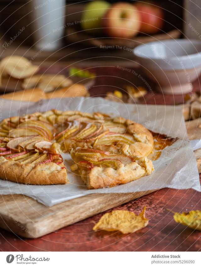 Frisch gebackener Apfelkuchen auf Backpapier Pasteten Herbst Blatt Mürbeteig selbstgemacht Schneidebrett Gebäck Galette Nudelholz lecker frisch Rezept