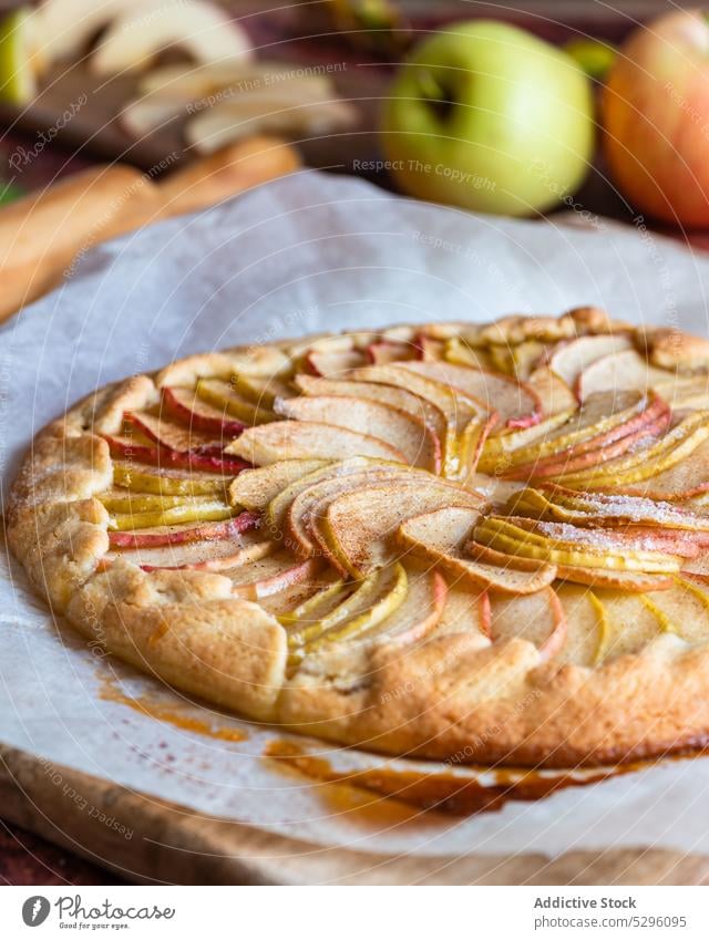 Frisch gebackener Apfelkuchen auf Backpapier Pasteten Herbst Blatt Mürbeteig selbstgemacht Schneidebrett Gebäck Galette Nudelholz lecker frisch Rezept