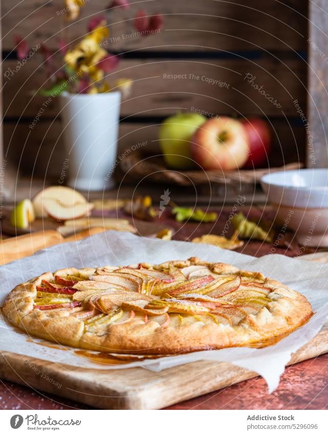 Frisch gebackener Apfelkuchen auf Backpapier Pasteten Herbst Blatt Mürbeteig selbstgemacht Schneidebrett Gebäck Galette Nudelholz lecker frisch Rezept