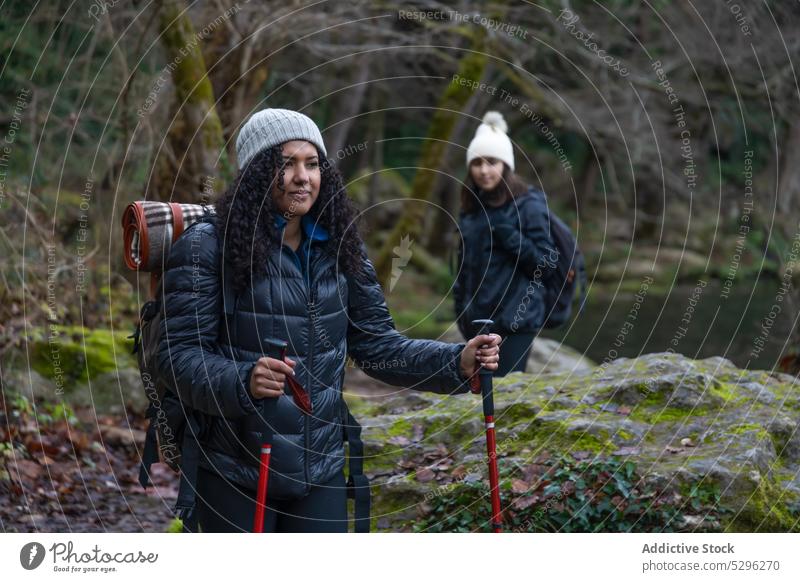 Fröhliche ethnische Frau und Mädchen bewundern die Natur Mutter Trekking See Tochter Abenteuer Wanderung Ausflug Wanderer erkunden Ufer reisen Reisender kleben