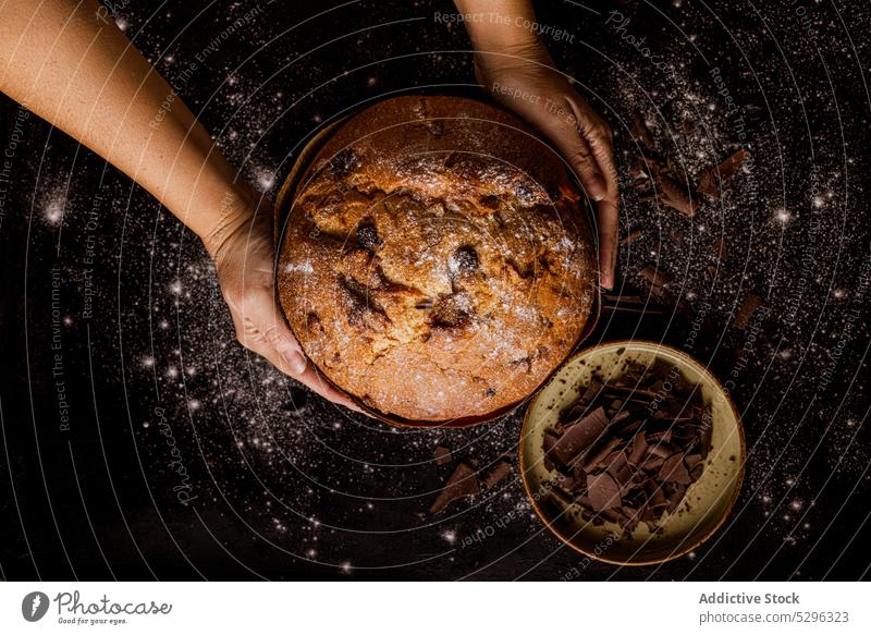 Frau hält einen leckeren Panettone, einen berühmten italienischen Weihnachtskuchen mit Schokolade Brot Lebensmittel Bäckerei Feiertag traditionell Kuchen