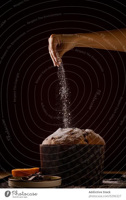 Frau gießt ein Zuckerglas auf einen leckeren Panettone, ein berühmtes italienisches Weihnachtsgebäck Brot Lebensmittel Bäckerei Feiertag traditionell Kuchen