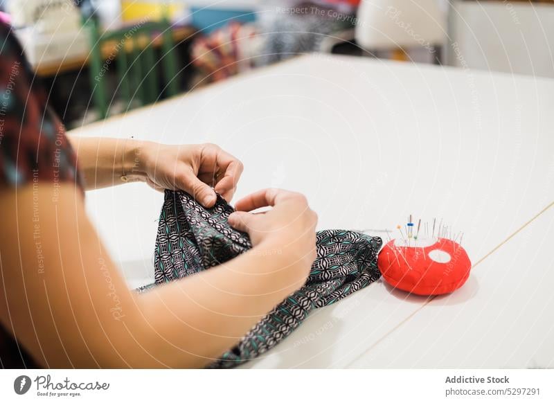 Schneiderin beim Nähen von Stoffen im Atelier Frau nähen Designer Näherin Muster Nadel Gewebe Textil Damenschneiderin Material Werkstatt Beruf Basteln Arbeit