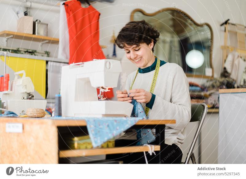 Gezieltes Schneidern an der Maschine im Atelier Frau Näherin Damenschneiderin Klebeband Designer Werkstatt messen Nähmaschine Muster Arbeit professionell