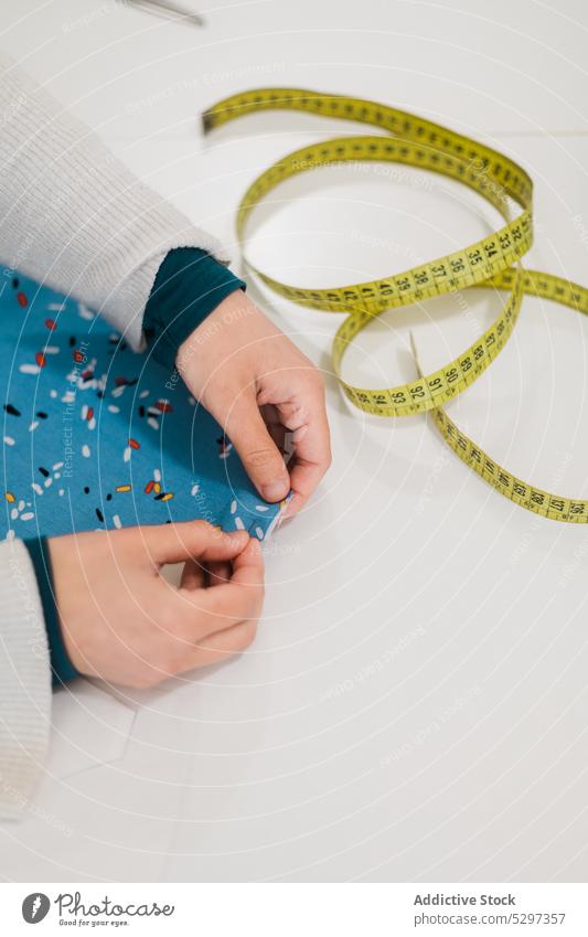 Crop-Designer näht auf Stoff im Atelier Damenschneiderin Stecknadel Nadel Näherin Mode messen Klebeband Werkstatt Muster Werkzeug Arbeit Handwerk Beruf