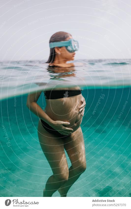 Unerkennbare schwangere Frau beim Tauchen im Meer schwimmen unter Wasser Fisch Sinkflug unterseeisch Urlaub MEER Bikini durchsichtig blau Feiertag reffen