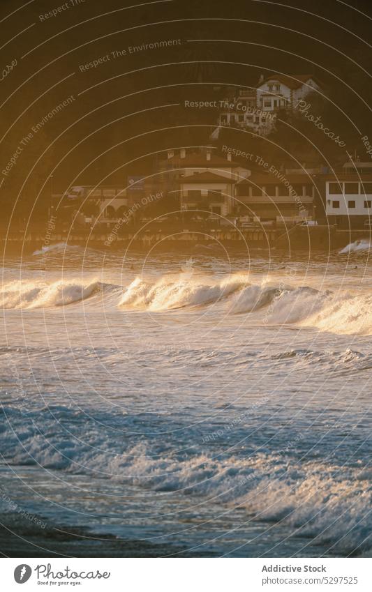 Welliges Meer wäscht Sandstrand winken MEER Sonnenuntergang Haus Strand Küste Küstenlinie schäumen Abend Gebäude Ufer Meeresufer Seeküste Wasser tropisch