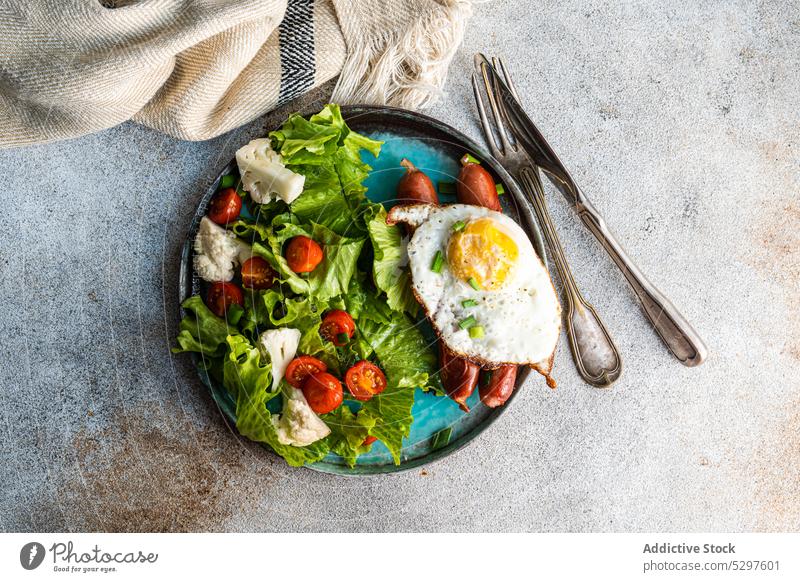 Mittagessen mit Salat und Würstchen Salatbeilage Frühstück Ei Lebensmittel Amerikaner Deutsch Hintergrund Käse Kirschtomate Beton Essen zubereiten Besteck Diät