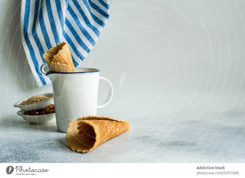 Waffeltüten und Nüsse für die Zubereitung von Speiseeis Zapfen Mandel gehackt kalt Beton Koch Essen zubereiten Tasse Delikatesse Dessert essen Lebensmittel