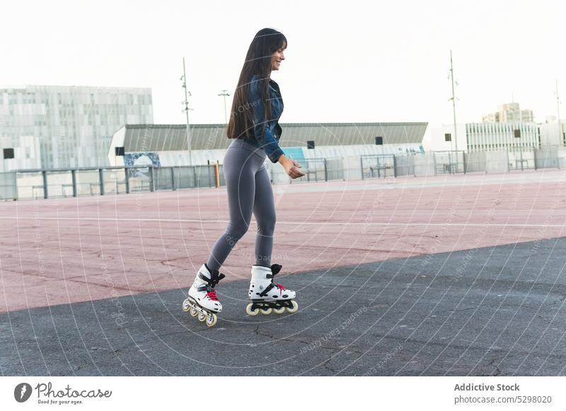 Lächelnde Frau auf Rollschuhen auf der Straße Mitfahrgelegenheit Rollerskate Schlittschuh Sommer Spielplatz Aktivität genießen Sport Glück Spaß jung lässig