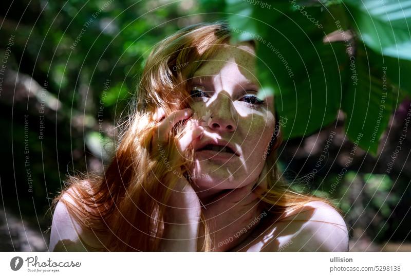 sinnliches Portrait junge schöne sexy rothaarige Frau im Freien im sonnigen Wald mit schönen roten Haaren und Sommersprossen, Licht und Schatten auf ihrem Gesicht