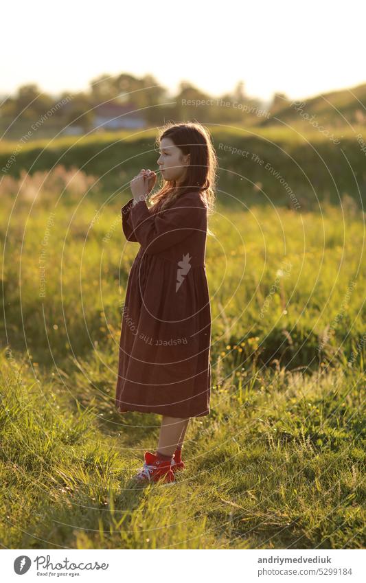 schöne niedliche kleine Mädchen spielen im Freien bei Sonnenuntergang, zu Fuß und Spaß haben, glückliche Kindheit. Sommer sonnigen Urlaub Natur Feld grün Glück