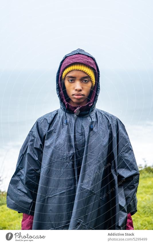 Ernste Frau im Regenmantel auf dem Meer während eines Ausflugs Wanderer Reisender Urlaub Porträt ernst Tourist MEER Tourismus Natur wolkenlos reisen jung Küste