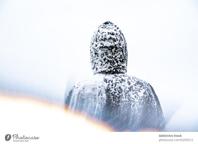 Gesichtsloser Tourist im Regenmantel mit Schnee bedeckt Reisender Kapuzenpulli Urlaub Deckung erkunden bewundern Natur Himmel stürmisch idyllisch Wetter Ausflug