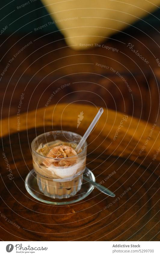 Ein Glas köstlicher Kaffee mit Eiscreme Speiseeis Baggerlöffel kalt Tasse trinken Getränk lecker süß Stroh frisch geschmackvoll Erfrischung hölzern dienen