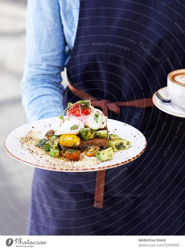 Person mit leckerem pochiertem Ei und Avocado-Toast mit Gemüse Zuprosten Brot wildert Paprika Kirsche Tomate geschmackvoll Belegtes Brot Grün frisch Kraut