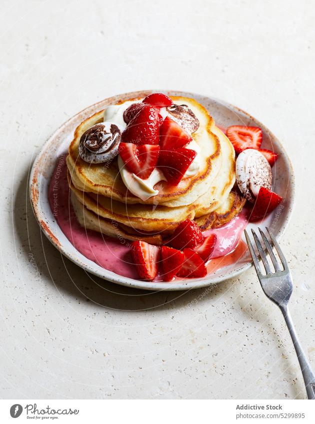 Leckere Pfannkuchen mit Erdbeeren und Sahne Joghurt Dessert süß lecker Lebensmittel Frühstück Teller Gabel appetitlich geschmackvoll frisch dienen Beeren