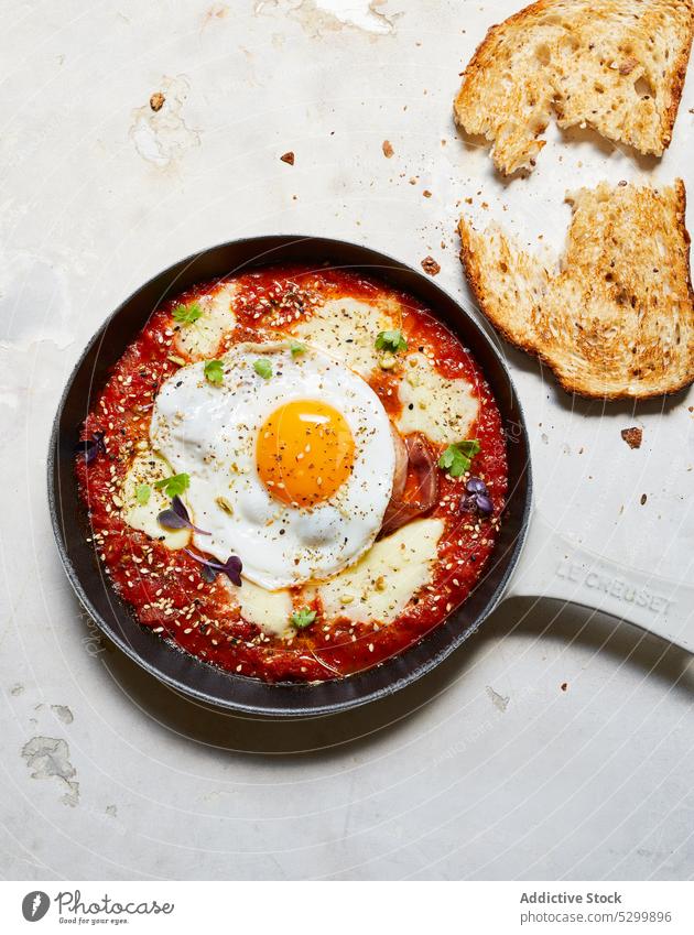 Leckeres Frühstück mit Spiegelei und Tomaten shakshuka Ei Pfanne Brot Käse Lebensmittel lecker appetitlich Tisch Küche geschmackvoll frisch Mahlzeit kulinarisch