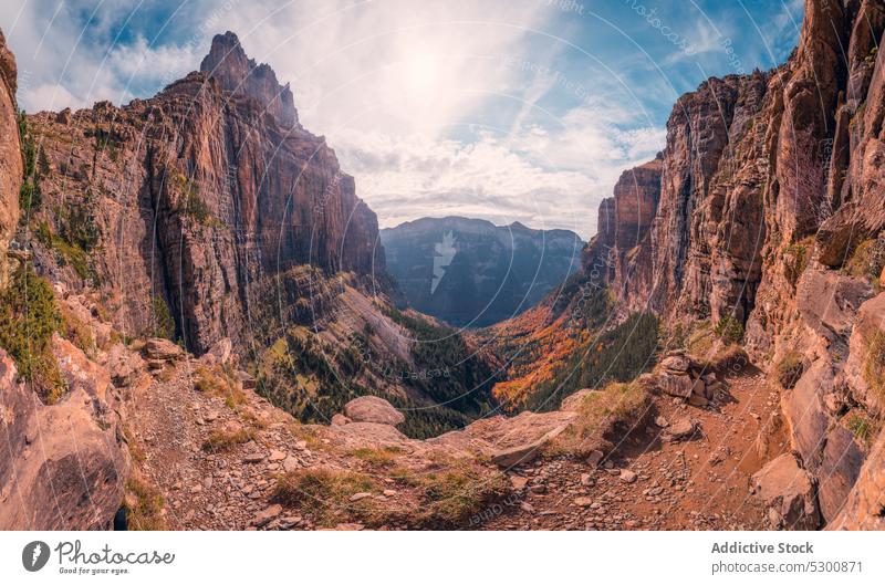 Felsige Berge mit wachsenden Bäumen unter bewölktem Himmel felsig Berge u. Gebirge uneben Berghang Baum Sonnenlicht Natur Landschaft Geologie massiv Odese