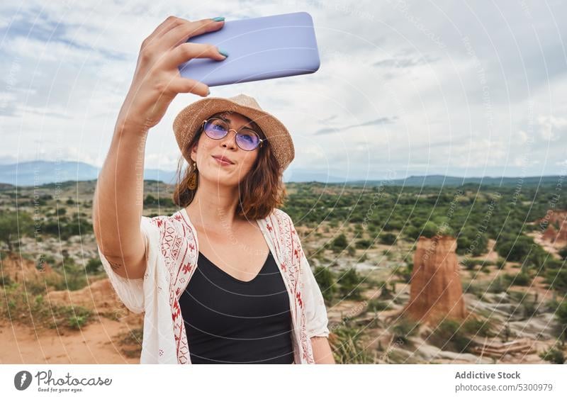 Lächelnde Frau nimmt Selfie auf Handy in der Wüste Reisender Berge u. Gebirge Smartphone trendy Glück Natur Urlaub Tatacoa-Wüste Kolumbien Sommer reisen