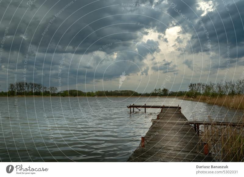 Bewölkter, stürmischer Himmel über einem See mit einem Steg Cloud Wasser Pier Landschaft Natur hölzern Horizont Unwetter winken wolkig reisen Regen Wetter blau