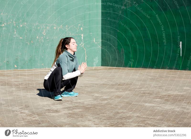 Ruhige Frau meditiert auf der Straße Yoga meditieren üben Girlandenpose Namaste Augen geschlossen malasaña Zen Windstille Achtsamkeit upaveshasana Asana jung