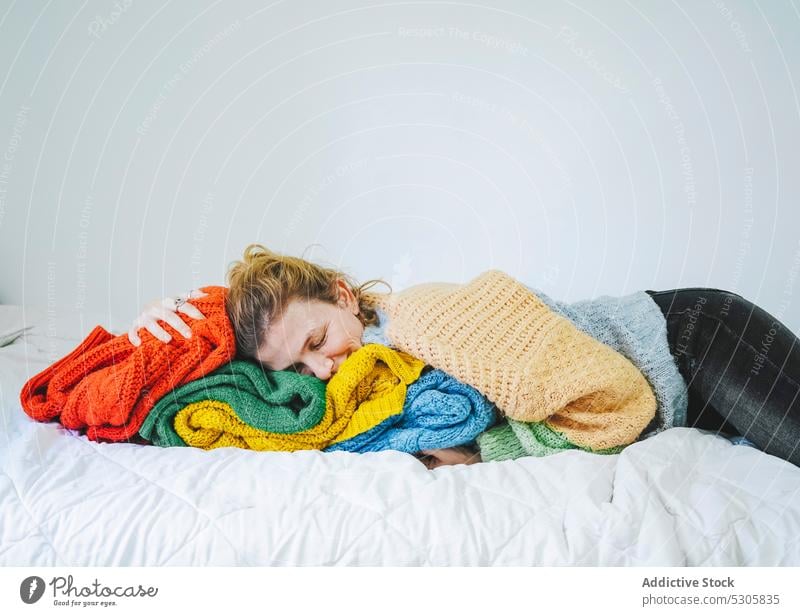 Entspannte Frau, die auf einem gestrickten Pullover auf dem Bett liegt Windstille Lügen Augen geschlossen Komfort sich[Akk] entspannen Stoff heimwärts