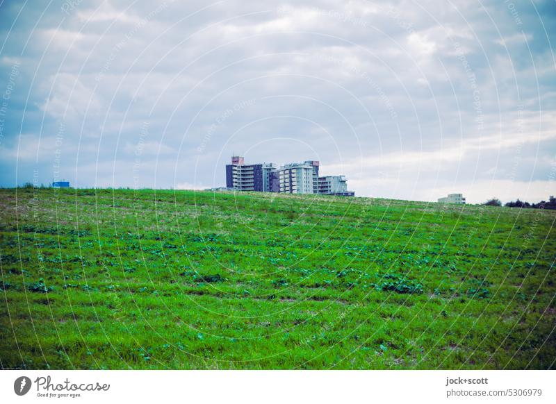 Stadtrandsiedlung hinter dem Hügel Wohnhochhaus Himmel Wolken Panorama (Aussicht) hervorragend Wiese Natur Landschaft Umwelt grün Hintergrund neutral Weite