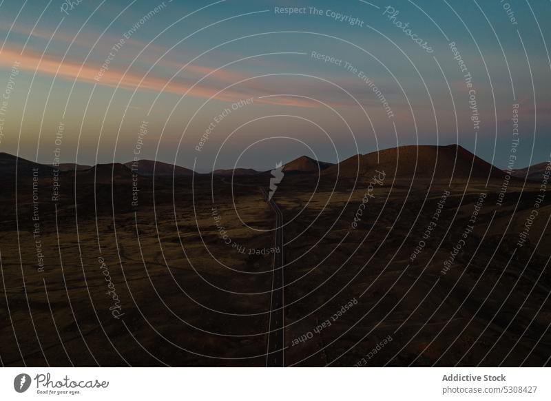 Drohnenansicht der Fahrbahn zwischen felsigen Bergen bei Sonnenuntergang Berge u. Gebirge Straße Landschaft Tal Natur Ambitus vulkanisch Hochland Autobahn