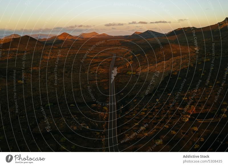 Drohnenansicht der Fahrbahn zwischen felsigen Bergen bei Sonnenuntergang Berge u. Gebirge Straße Landschaft Tal Natur Ambitus vulkanisch Hochland Autobahn