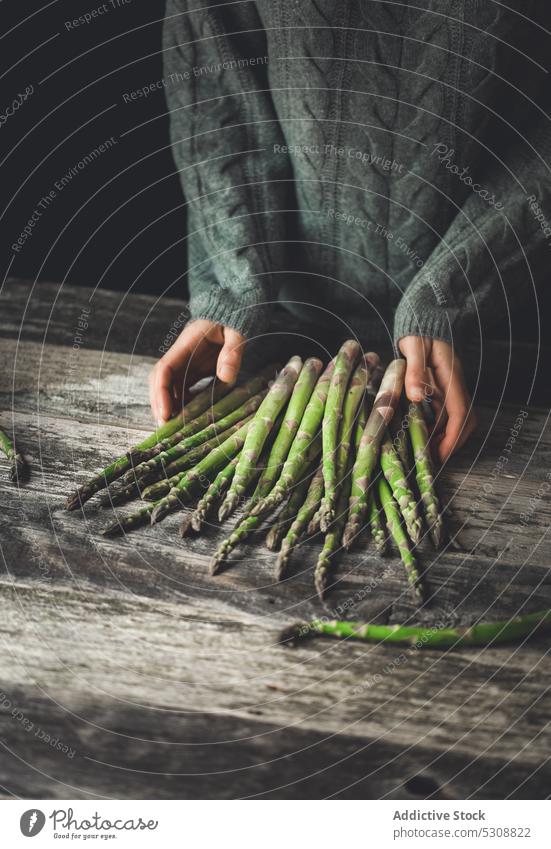 Erntehelfer mit Spargelbündel auf dem Tisch Person frisch natürlich organisch Gesundheit Gemüse reif vorbereiten hölzern Vorbau Pullover grün Pflanze Vitamin